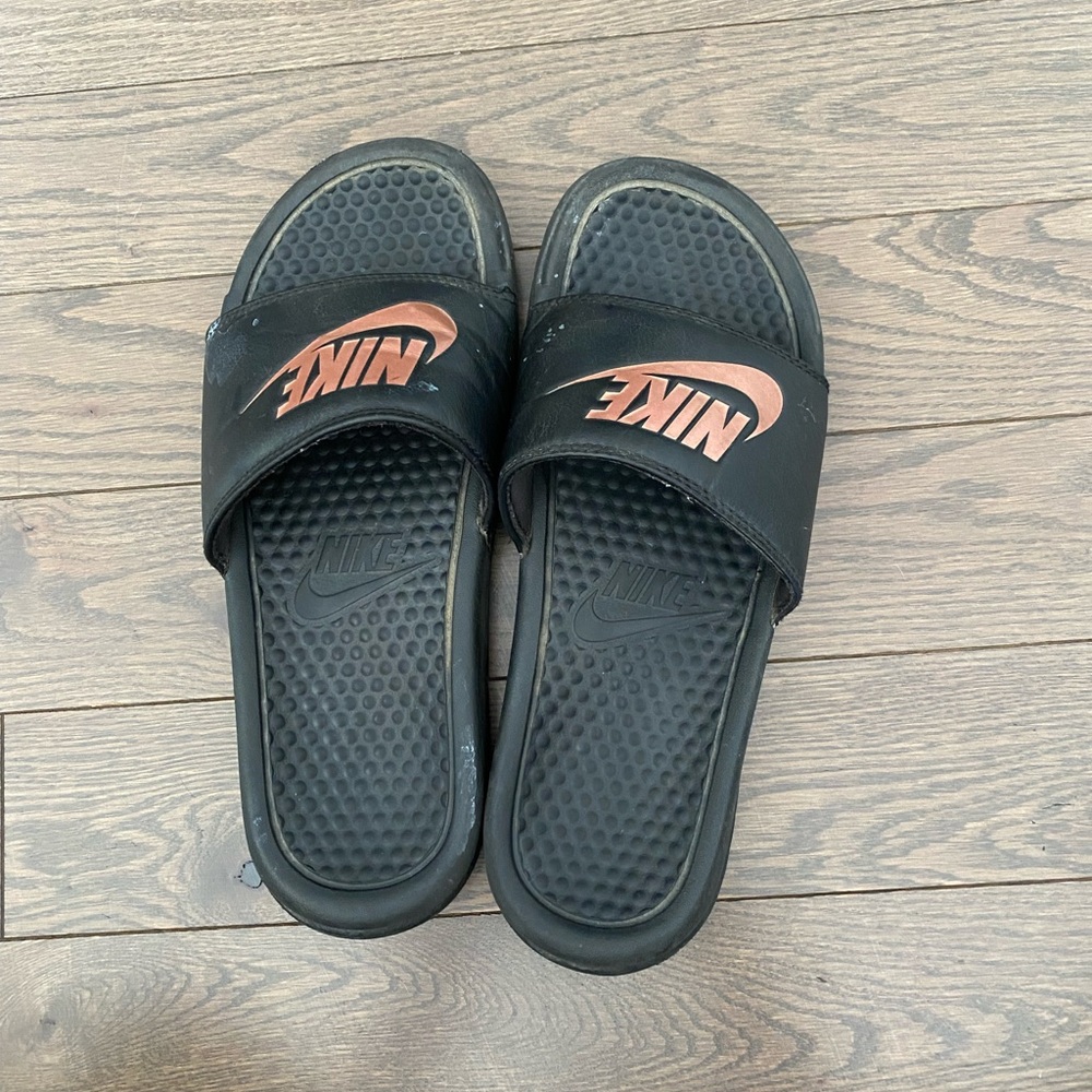 Black Nike slides with rose gold logo